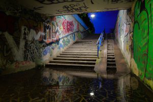 Überflutung in einer Unterführung, die Treppe zum Ausgang ragt aus dem Wasser.