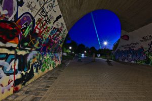 Laserstrahl am Himmel am Ende einer Unterführung.